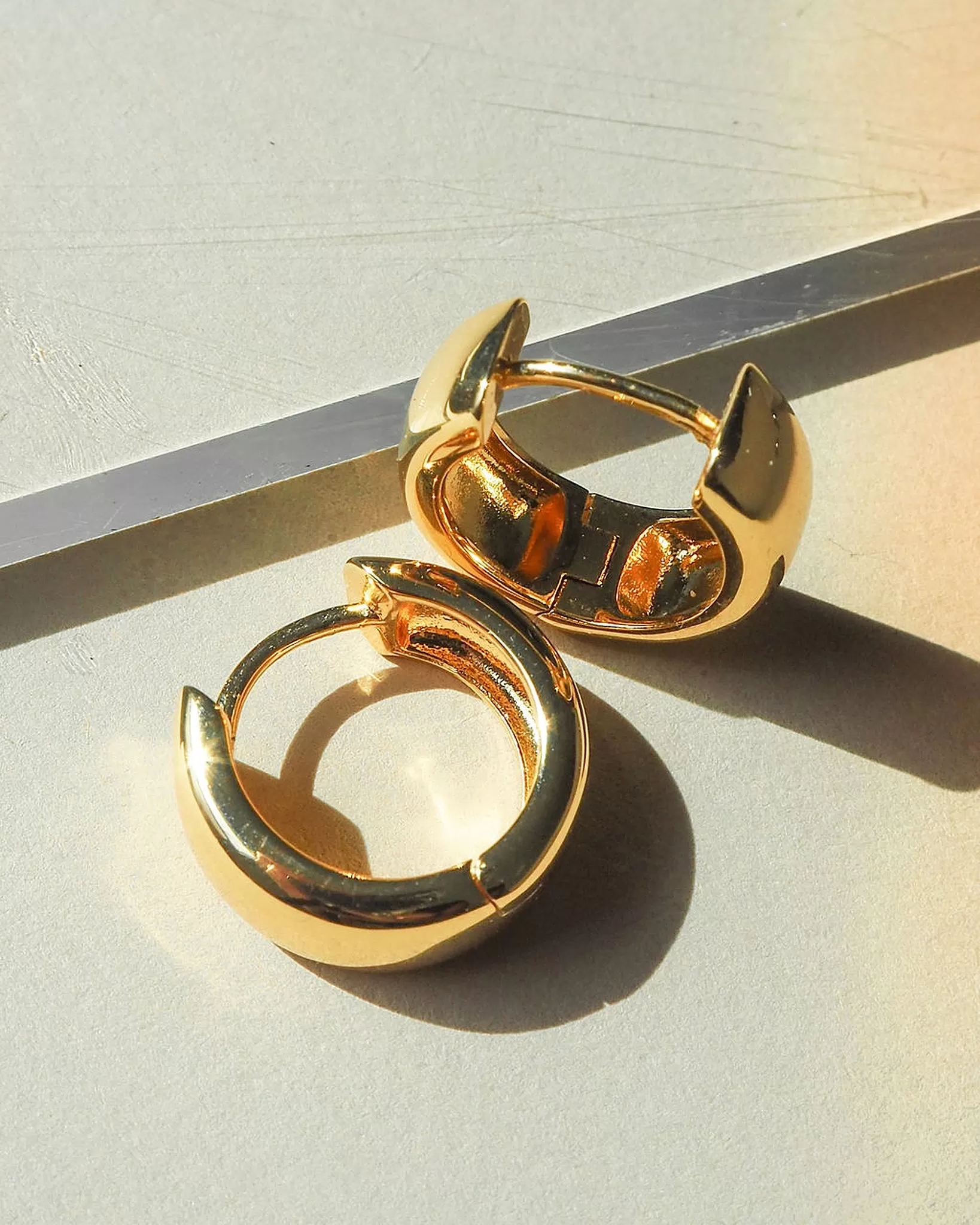 Luv Aj Monaco Wide Huggie Hoop Earrings in Polished Gold Plated